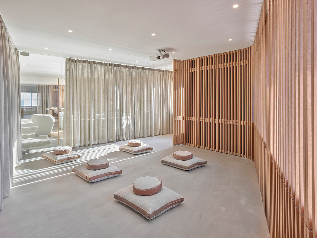 Minimalist interior with wooden slat wall, neutral tones, and meditation cushions.
