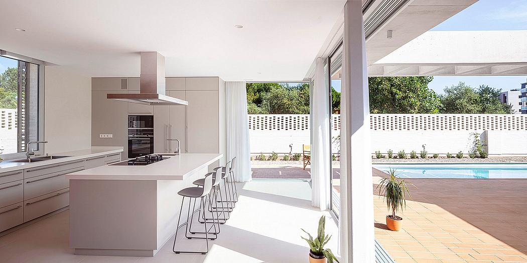 Spacious modern kitchen with sleek appliances, overlooking an outdoor patio and pool.