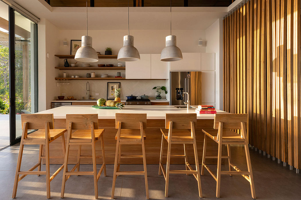 Modern kitchen with wooden bar stools, shelves, and concrete pendant lights.
