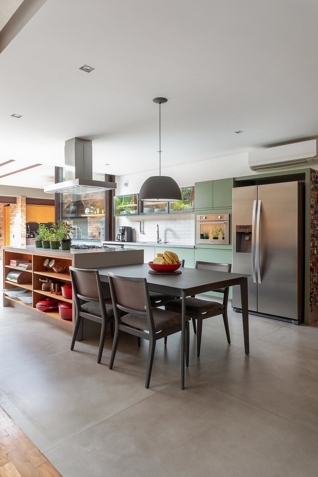 Modern, open-concept kitchen and dining area with sleek cabinetry, pendant lighting, and a large dining table.