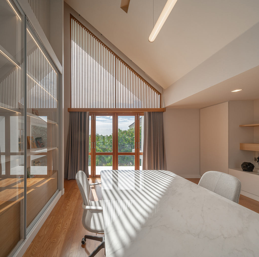 Spacious, well-lit dining room with wood-paneled windows and a marble-topped table.