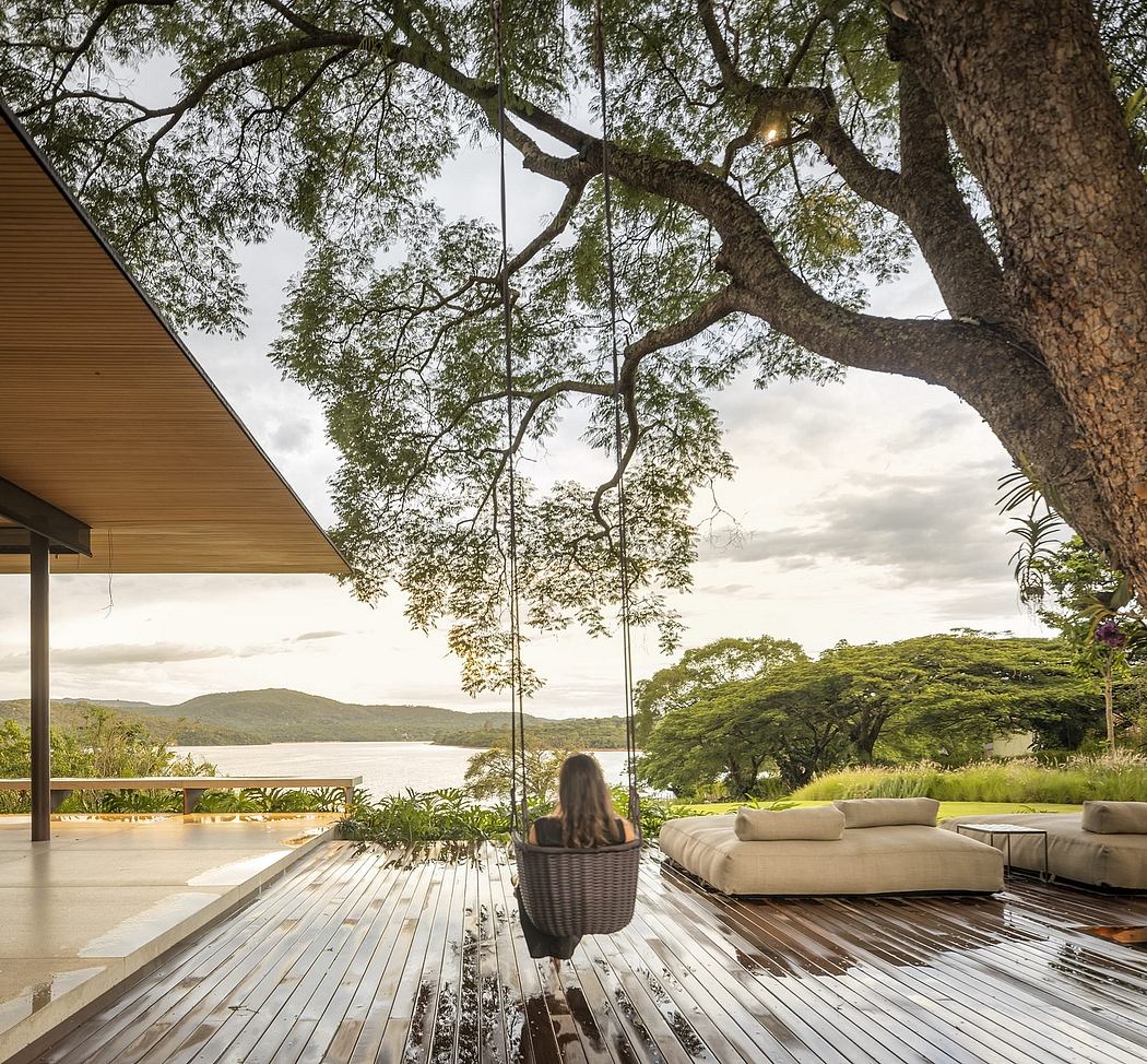 Serene outdoor lounge area with wooden deck, plush seating, and lush natural surroundings.
