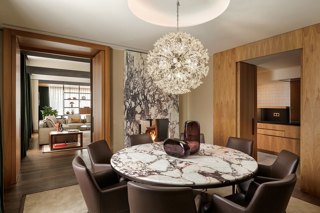 Elegant dining room with marble table, plush leather chairs, and a stunning crystal chandelier.