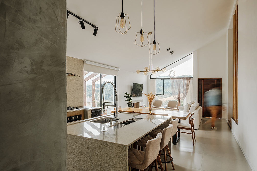 A modern kitchen with a minimalist design, featuring pendant lighting, wood accents, and an island.