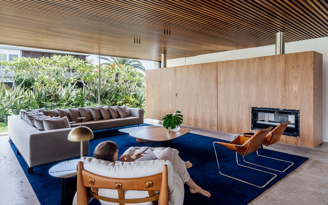 Modern, open-plan living space with wooden ceilings, plush seating, and lush indoor greenery.