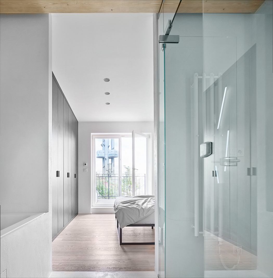 Sleek, modern bedroom with glass shower enclosure, built-in closets, and natural light.