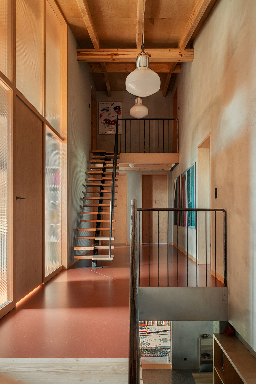 A cozy loft with exposed wooden beams, a spiral staircase, and a mix of modern and vintage decor.
