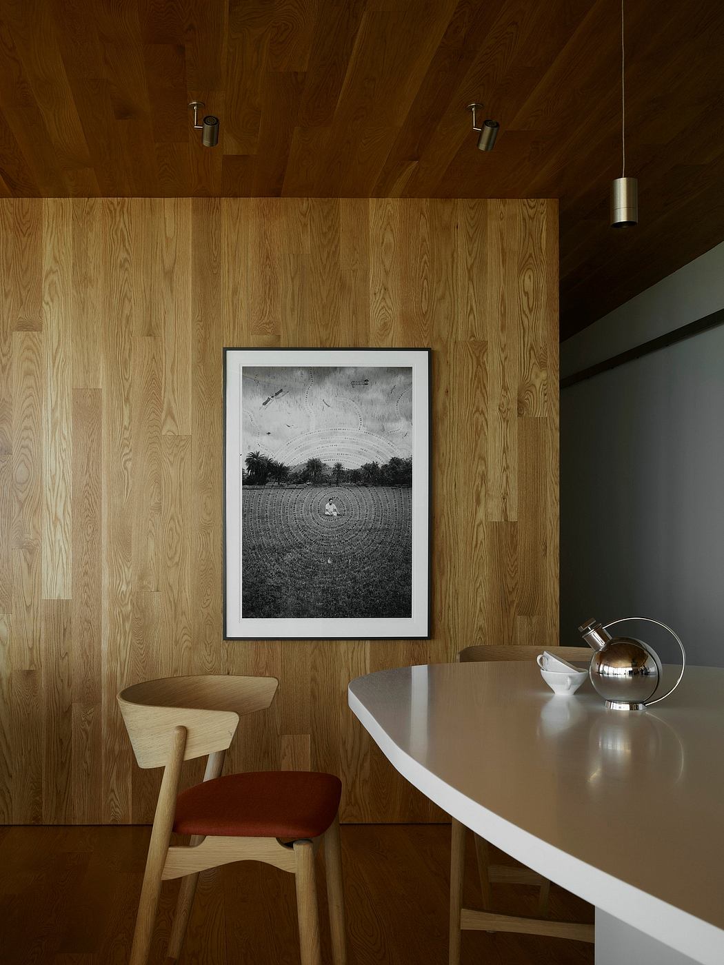 Minimalist, wood-paneled interior with a framed black-and-white landscape photograph.