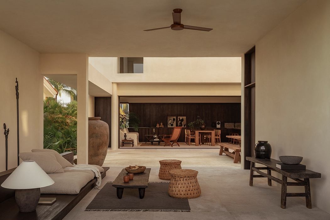 Spacious open-concept living area with earthy tones, natural materials, and lush greenery.
