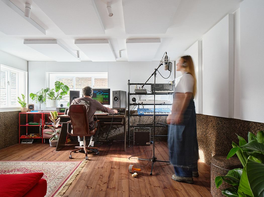 Bright, modern studio space with mixed materials, plants, and audio equipment.