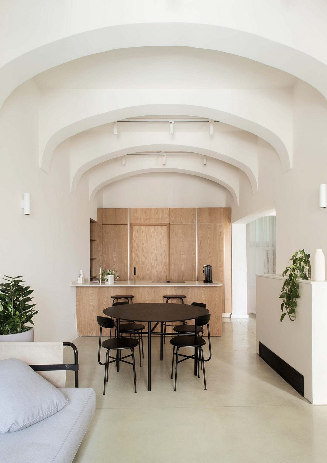 Contemporary dining area with vaulted ceiling and warm wood cabinetry.