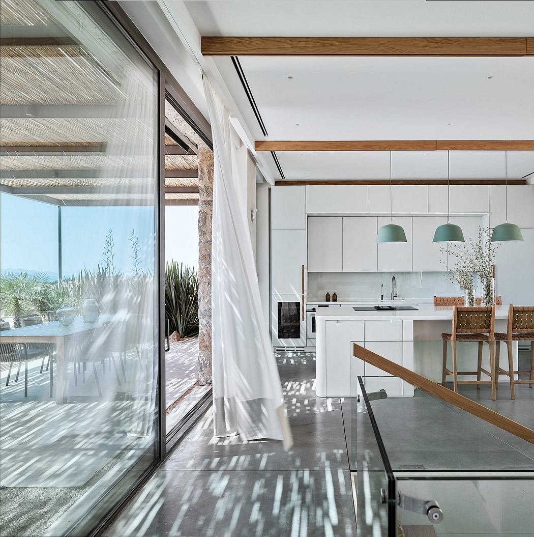 Sleek, modern kitchen with expansive windows, wooden beams, and minimalist decor.