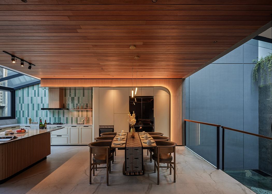 A modern, open-concept kitchen and dining area with warm wood ceilings, tiled walls, and large windows.