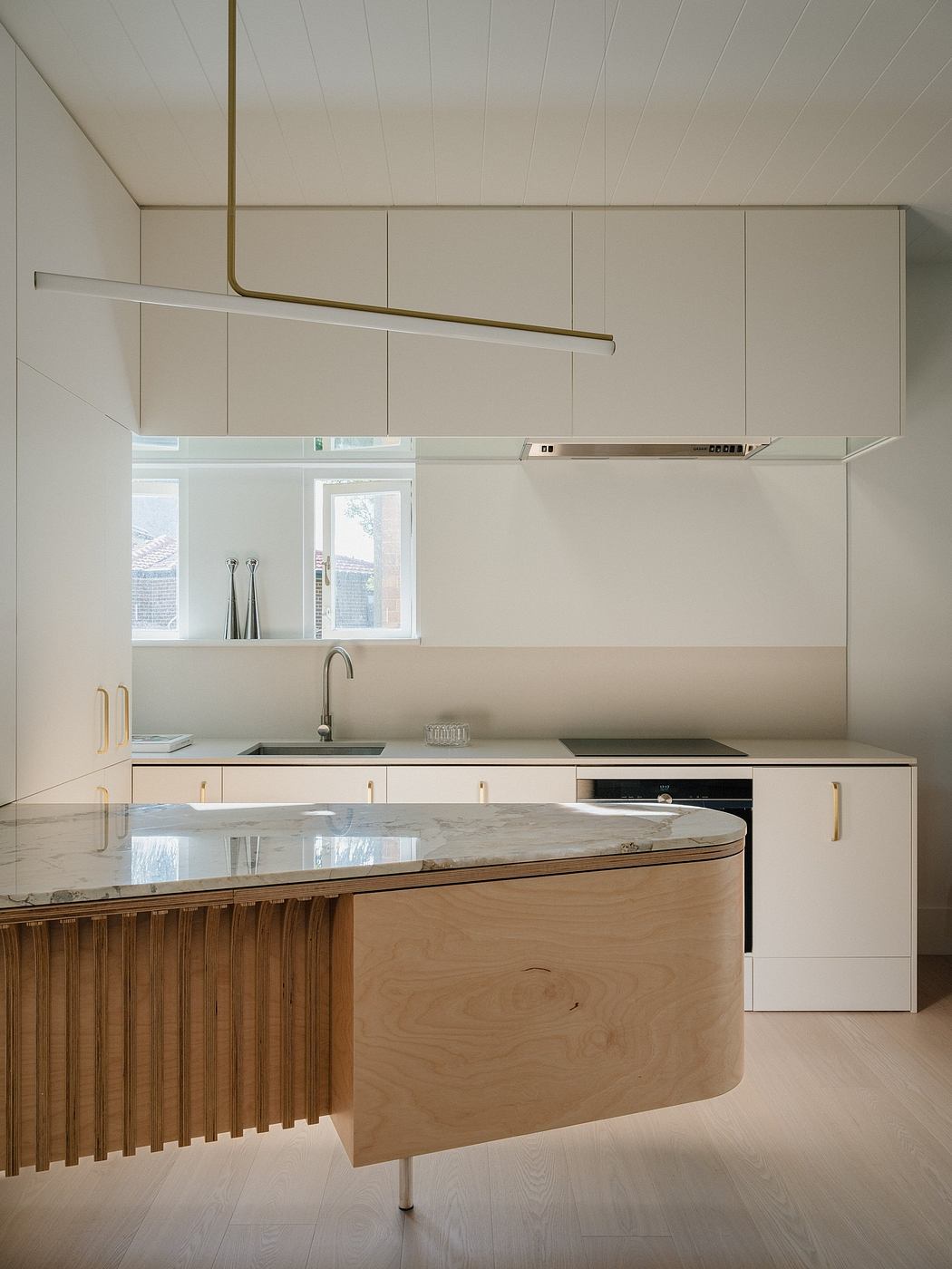 Sleek, modern kitchen design featuring wood accents, marble countertops, and recessed lighting.