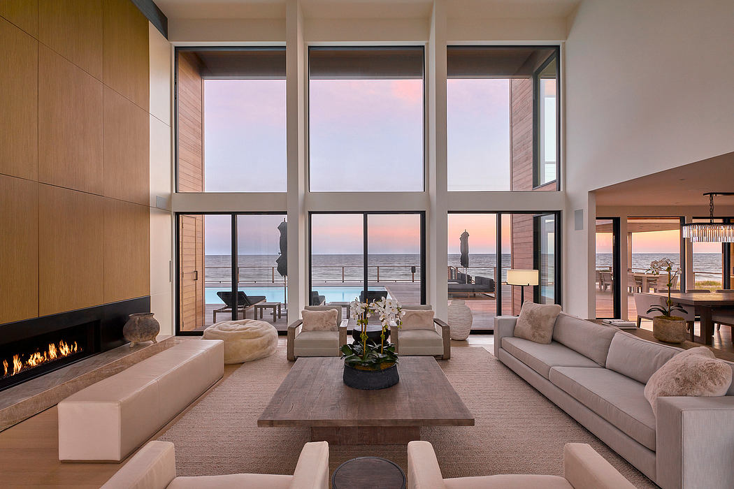 Spacious modern living room with large windows showcasing a sunset view and fireplace.