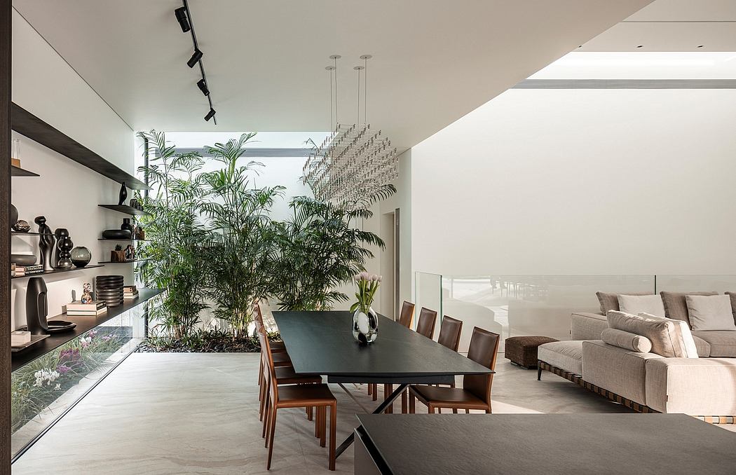 Spacious open-concept interior with tropical plants, modern furniture, and sleek lighting.