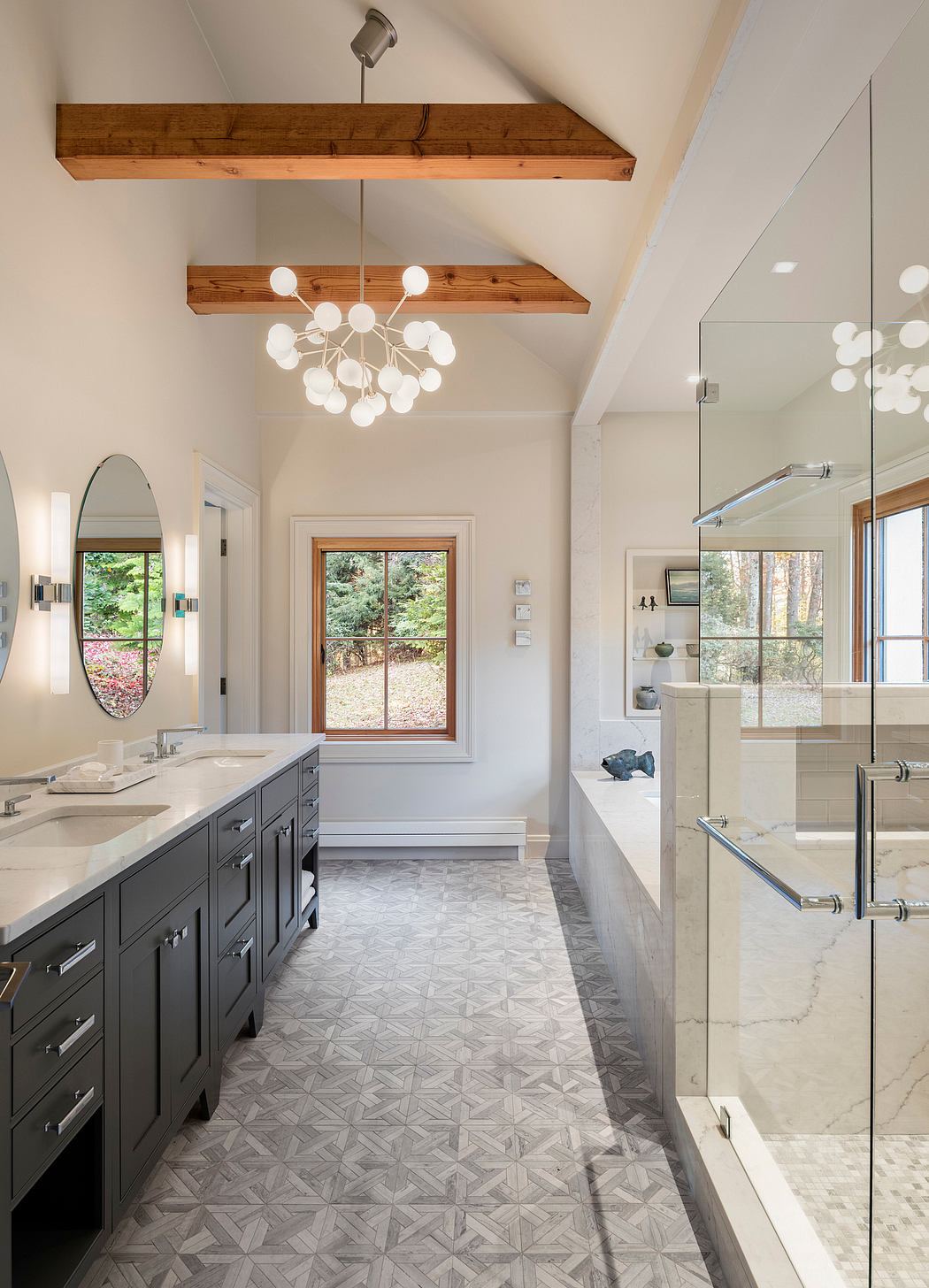 Modern rustic bathroom with patterned tile flooring, dark vanity, and overhead lighting.