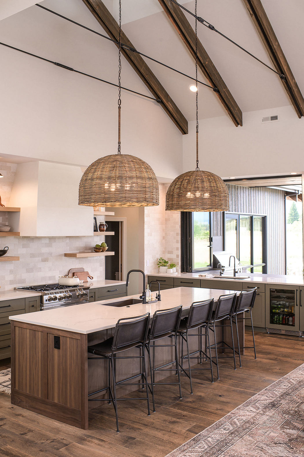 Spacious open-concept kitchen with wooden beams, woven pendant lights, and modern appliances.
