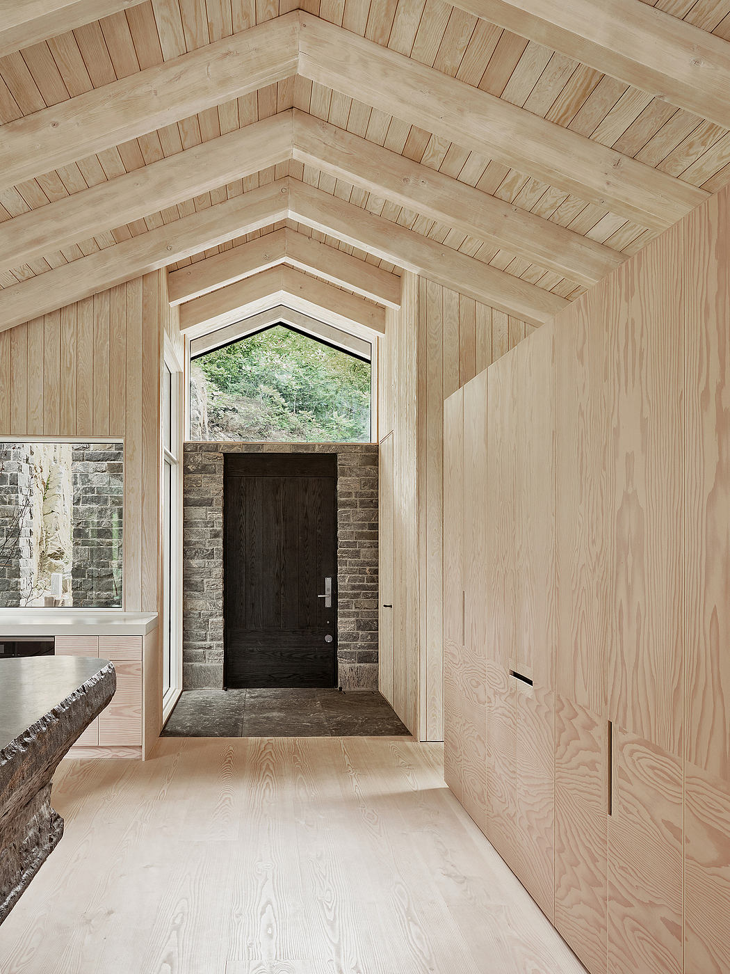 Rustic wooden ceiling beams, arched window, and brick entryway create a cozy atmosphere.