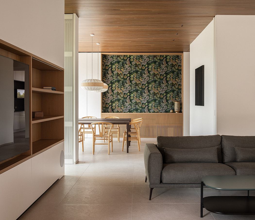 Modern, open-plan living space with wooden ceiling, floral accent wall, and minimalist furnishings.