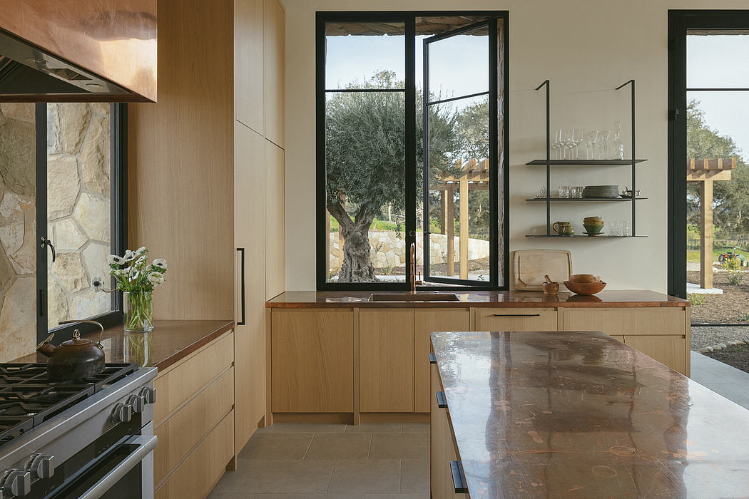 Spacious kitchen with expansive windows overlooking a lush outdoor landscape.