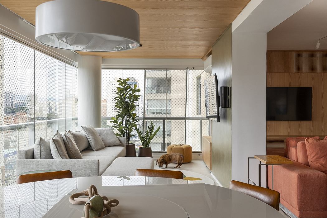 A modern, open-concept living space with wooden ceilings, large windows, and a cozy sofa.