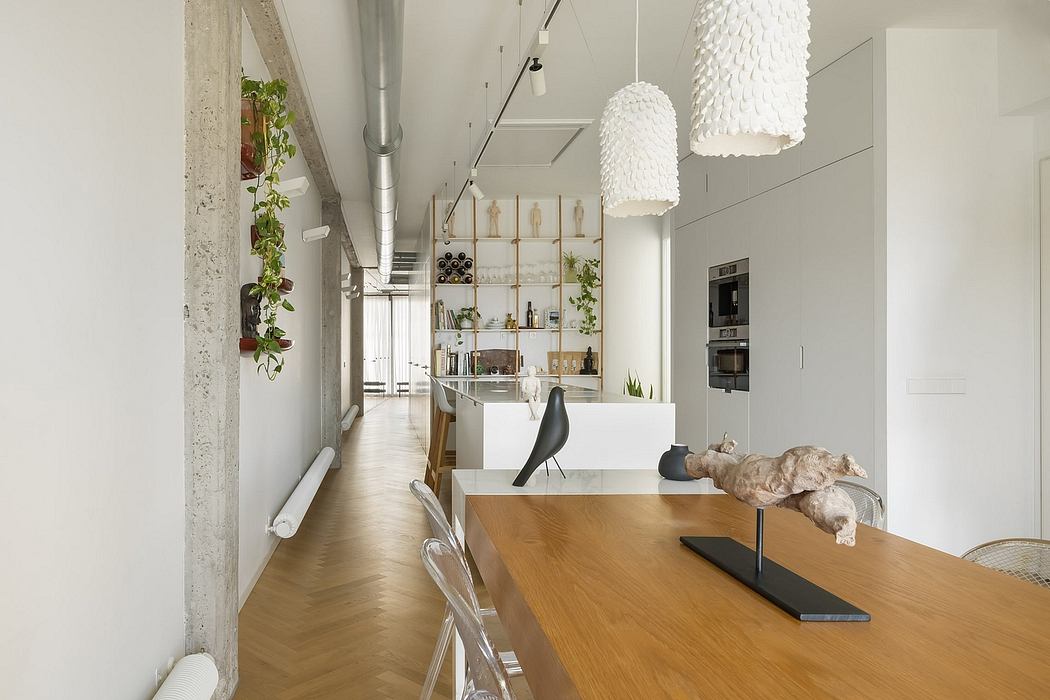 Modern open-concept kitchen with industrial-style decor, pendant lighting, and wooden dining table.
