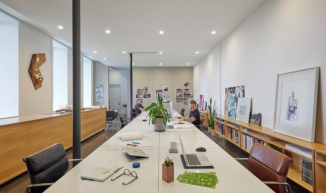 Modern, minimalist office space with clean lines, natural wood, and art displays.