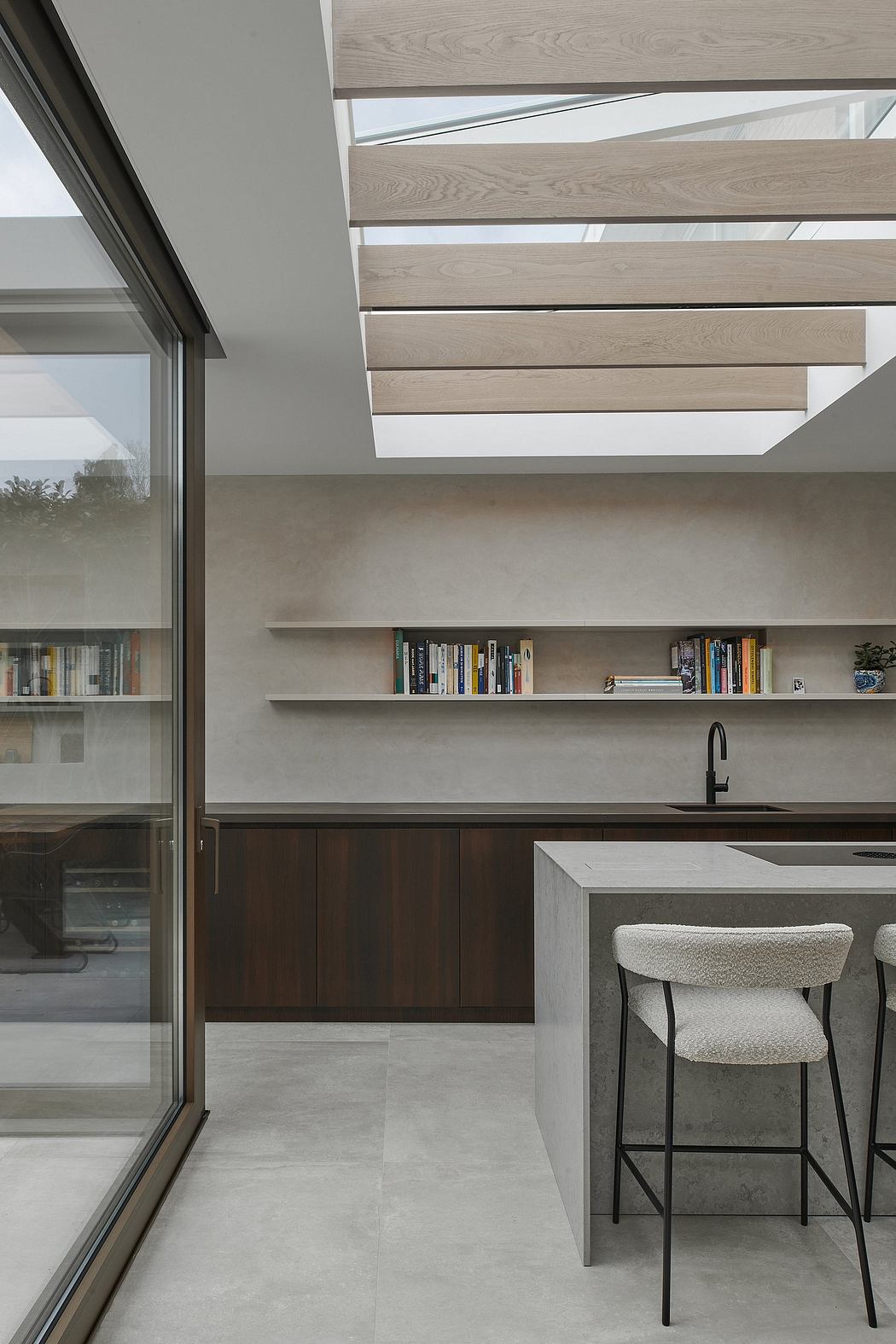 Modern minimalist kitchen with sleek wooden shelves, concrete countertop, and large windows.
