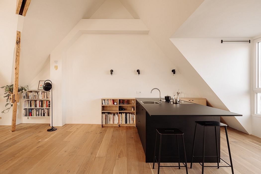 Minimalist attic kitchen with wooden floors, built-in shelves, and a black countertop.