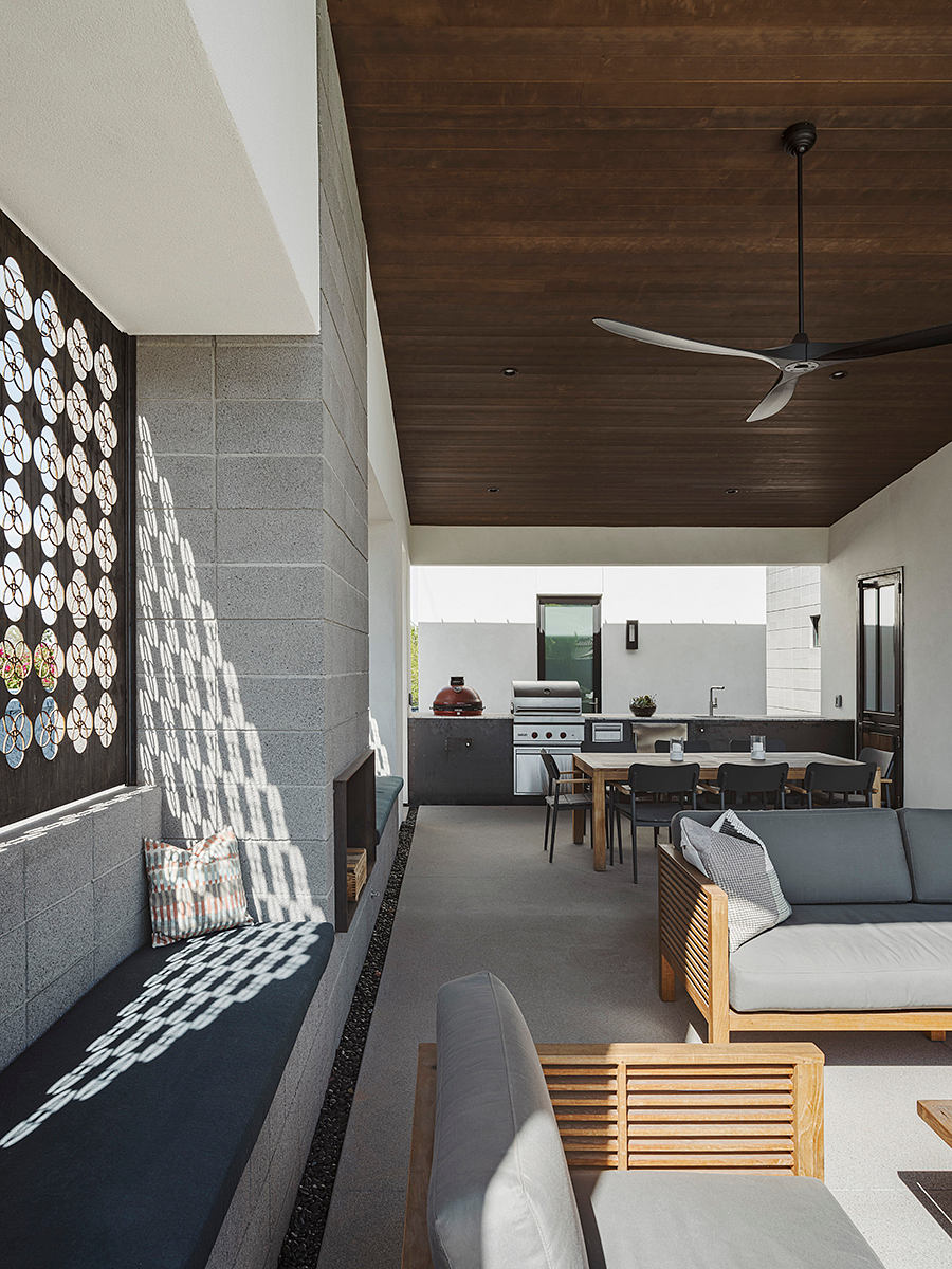 Well-designed open-concept living space with modern wood-paneled ceiling, sleek kitchen, and plush seating.