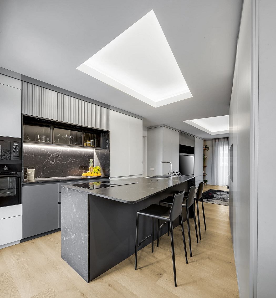 Sleek, modern kitchen featuring sleek black cabinetry, marble countertops, and a dramatic skylight.