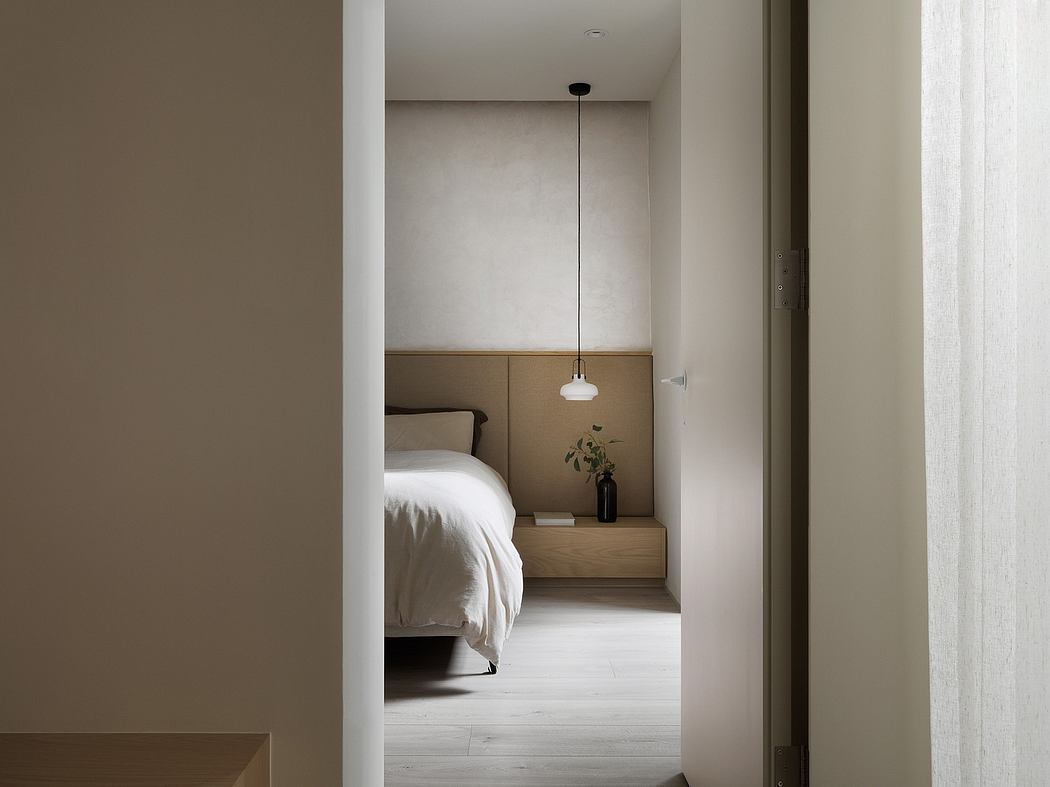 Cozy bedroom with neutral tones, floating nightstand, and minimalist light fixture.