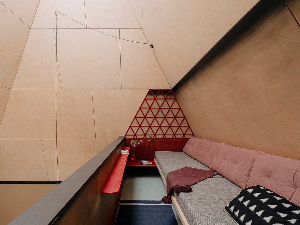 Minimalist and geometric interior design with triangular wall panel and cozy sofa.