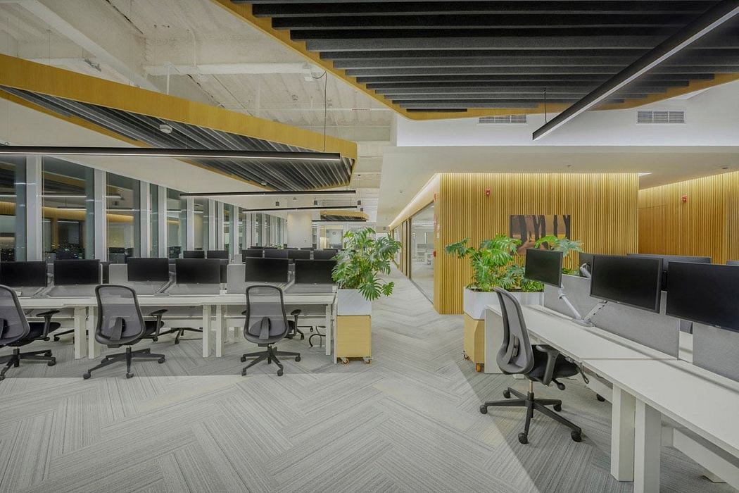 Sleek, modern office space with geometric ceiling patterns and warm lighting.