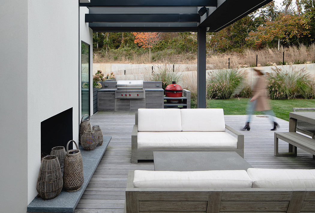 Sleek outdoor kitchen and living area with modern furnishings and natural landscaping.