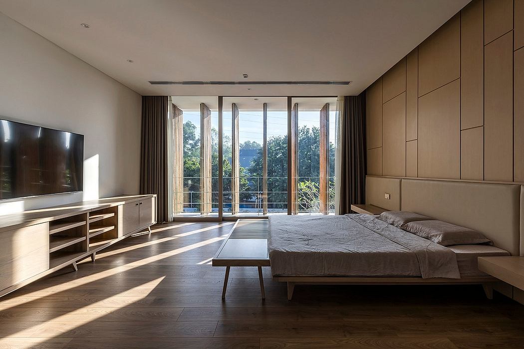Spacious bedroom with floor-to-ceiling windows, built-in cabinetry, and minimalist furnishings.