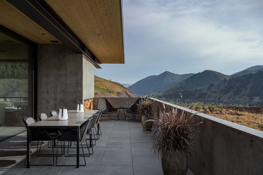 Modern mountain lodge with large terrace, wooden accents, and panoramic views.