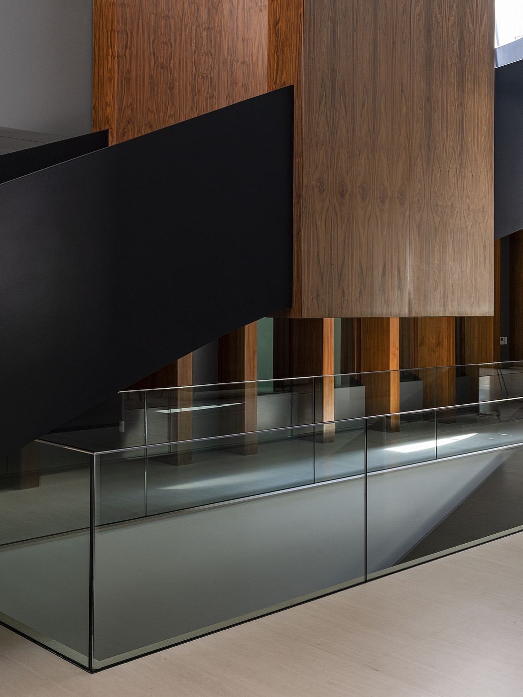 A modern, minimalist design featuring glass partitions and wood paneled walls.