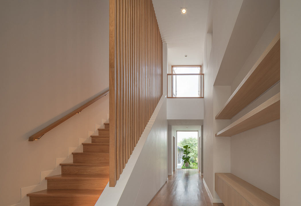 Vertical wooden panels frame the staircase and hallway, creating a warm, modern aesthetic.