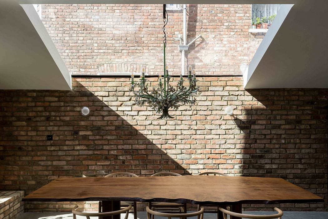 A rustic dining area with an overhead chandelier and exposed brick walls, providing a cozy ambience.