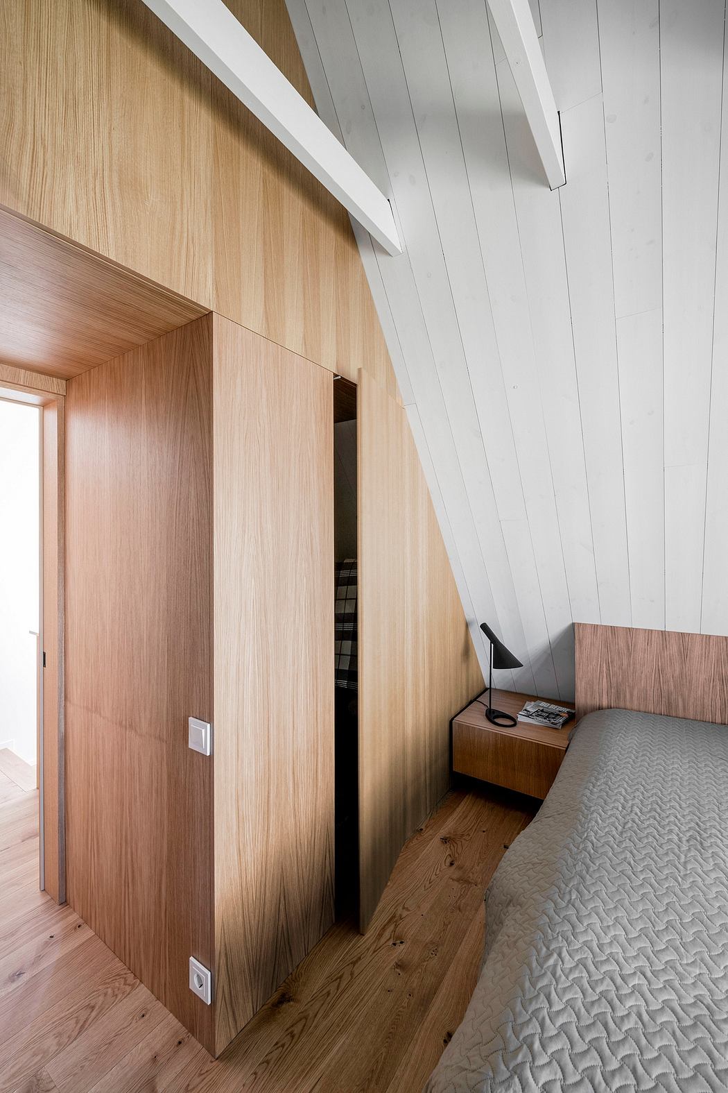 Warm-toned wooden panels and clean, minimal furniture design in modern bedroom.
