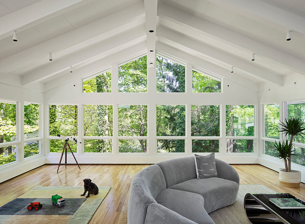 A bright, spacious room with floor-to-ceiling windows offering a lush, verdant view.