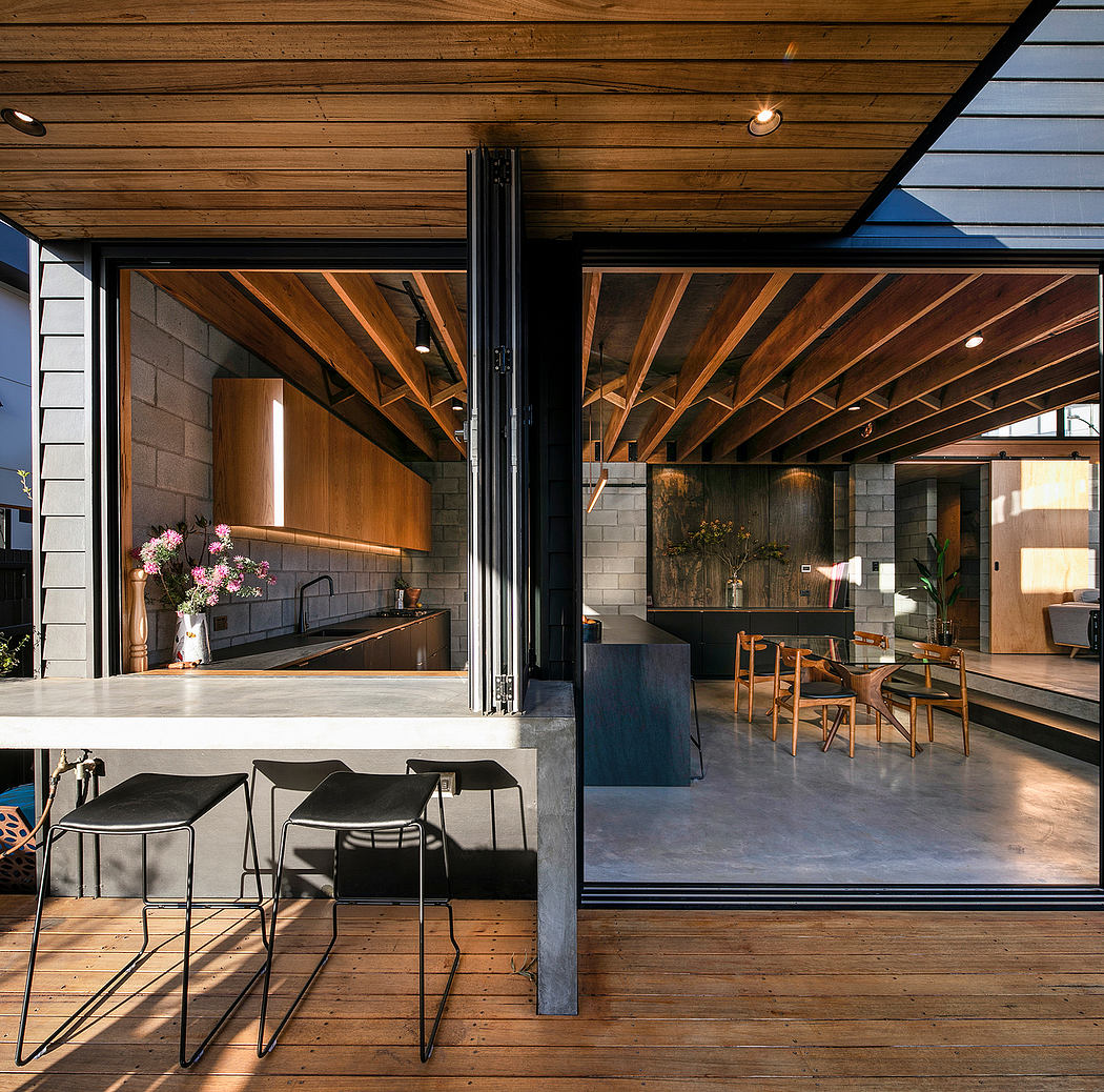 Rustic wooden beams, sleek black furniture, and a modern glass wall create a cozy, sophisticated interior.