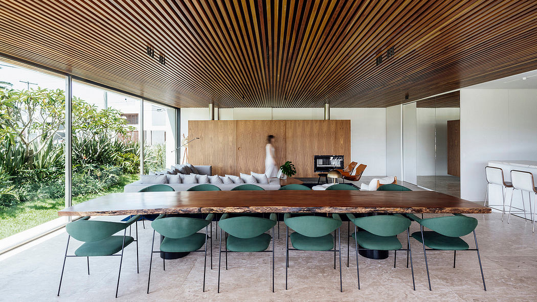 Spacious room with intricate wooden ceiling, large table, and comfortable green chairs.