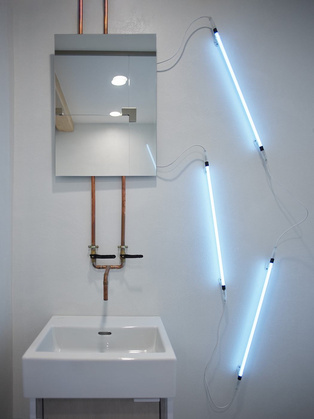 Sleek, minimalist bathroom design with modern vanity, mirror, and vibrant LED lighting.