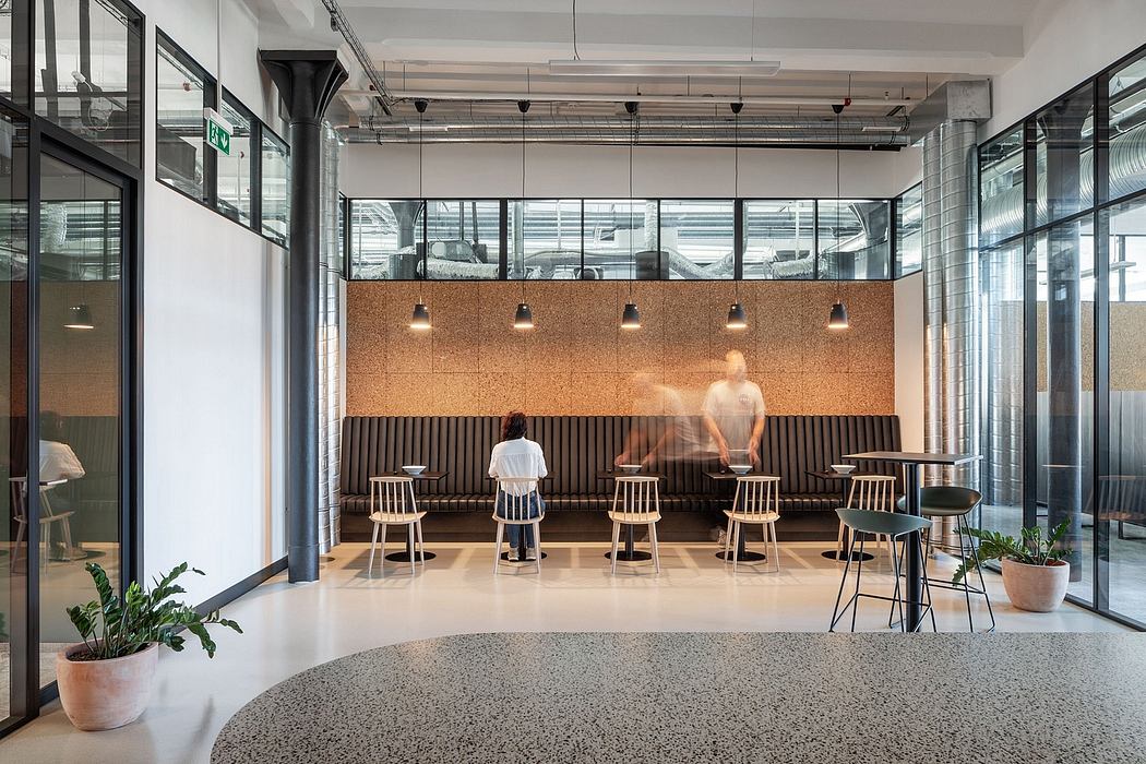Sleek, modern office space with cork wall, wooden chairs, and industrial lighting fixtures.