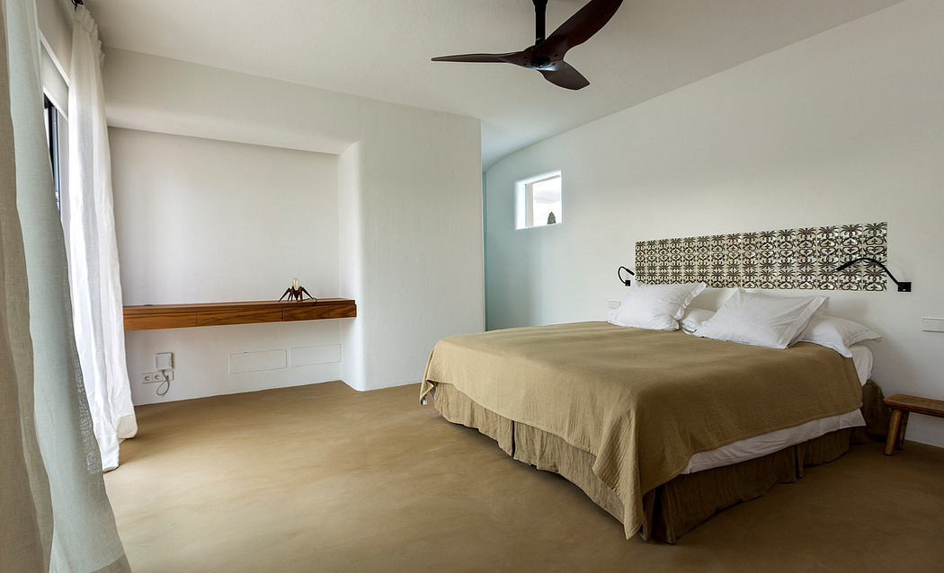 Minimalist bedroom with wooden shelf, ceiling fan, and patterned headboard decor.