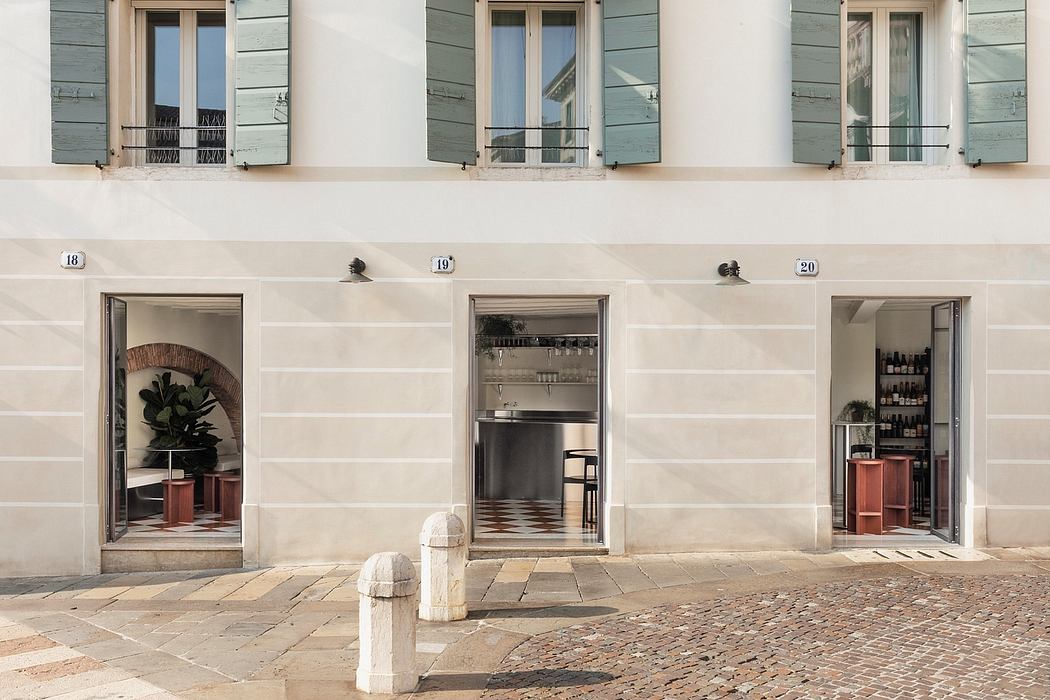 Quaint storefront with arched doorways, ornamental accents, and a cobbled paved entryway.