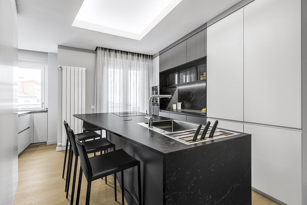 Modern kitchen with sleek black countertops, built-in appliances, and minimal decor.